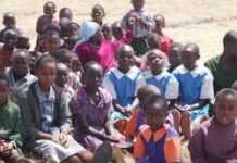 Enfants assistant à un cours sous un arbre, dans un camp de déplacés