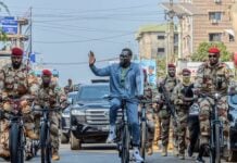 Le Président guinéen Mamadi Doumbouya salue la foule lors d'une promenade en vélo à Conakry